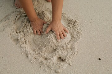 Hands of a child digging in sand