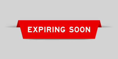 Red color inserted label with word expiring soon on gray background