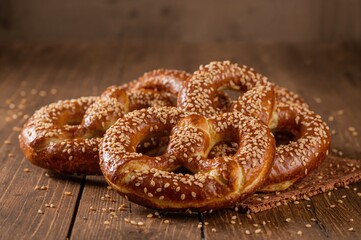 Assorted pretzels garnished with sesame seeds on a rustic wooden surface