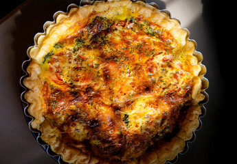 Delicious homemade french quiche with spinach, meat, tomato, and cheese