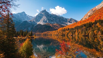 Fototapeta premium A serene alpine lake mirrors colorful fall leaves and rugged peaks in a peaceful mountain setting
