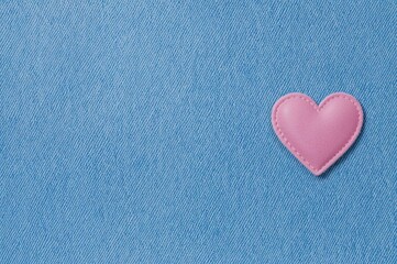 Obraz premium Soft blue jean fabric featuring a felt heart patch. Horizontal denim texture in blue with a heart-shaped textile accent. Romantic themed denim background with space for writing.