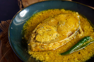 Traditional Bengali hilsa fish curry cooked in sesame seed and coconut gravy, authentic homemade Ilish recipe from Bengal, rich and flavorful Indian fish curry served with steamed rice