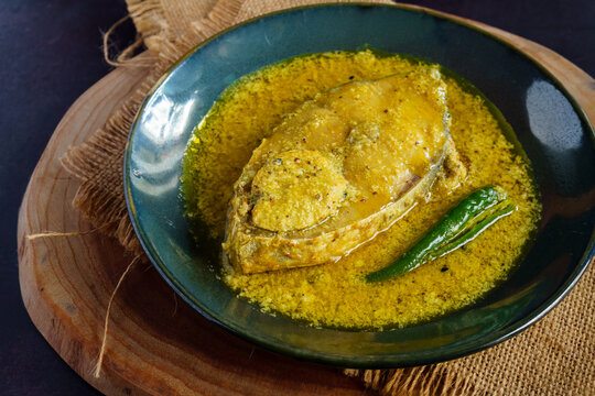 Traditional Bengali hilsa fish curry cooked in sesame seed and coconut gravy, authentic homemade Ilish recipe from Bengal, rich and flavorful Indian fish curry served with steamed rice