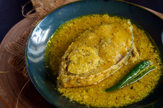 Traditional Bengali hilsa fish curry cooked in sesame seed and coconut gravy, authentic homemade Ilish recipe from Bengal, rich and flavorful Indian fish curry served with steamed rice