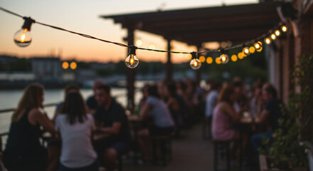 Evening social scene at riverside cafe with string lights glowing