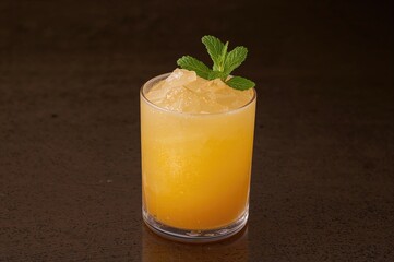 Iced mango cocktail decorated with fresh mint leaves