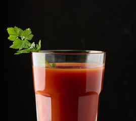A full glass of tomato juice and a sprig of parsley