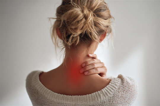 Rear View of Blonde Woman Suffering from Neck Pain