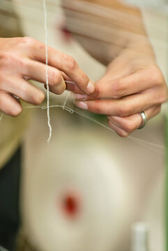 Industria textil, maos consertando os fios nos teares 