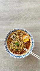 Delicious Instant Noodle Soup with Egg Half, Vegetables and Crackers with Chopsticks