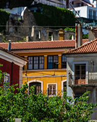 Lisbon, Portugal - Row of houses with a yellow house in the middle. The houses are all different colors. The yellow house has a balcony