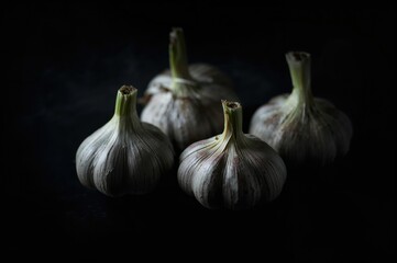 Obraz premium Cloves of garlic against a black backdrop