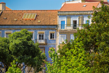 Lisbon, Portugal - Row of buildings with blue tiles and red roofs. The buildings are tall and have...