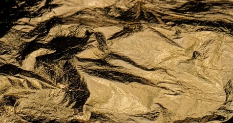 Linear Glide Over Crumpled Gold Foil Surface. Steady horizontal pan across wrinkled metallic gold material - Powered by Adobe