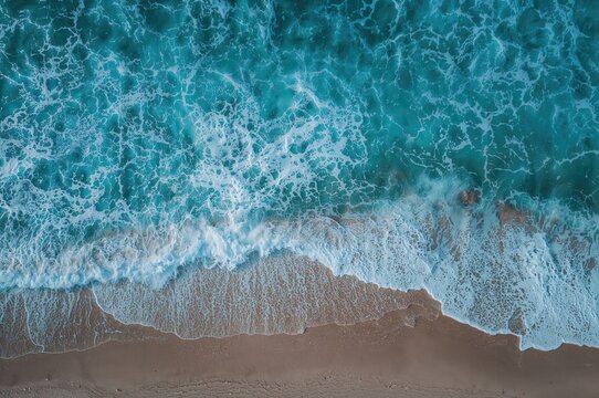 Aerial view of sea waves crashing on the shore, abstract nature landscape with light and water elements - Powered by Adobe