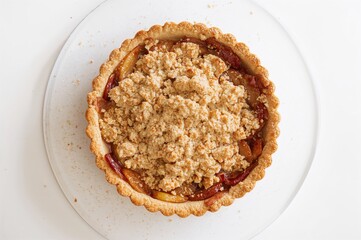 Tasty homemade apple crumble dessert on a plain white surface. Classic apple tart. Top view.