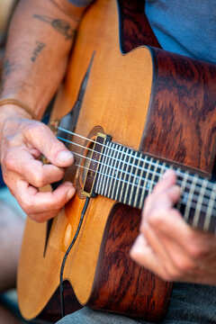 A musician playing a beautiful gypsy jazz guitar outdoors The Joy of a Live Musical Performance