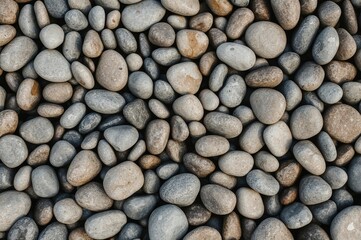 Detailed close-up of smooth, rounded stones outdoors, ideal for natural and landscaping themes.