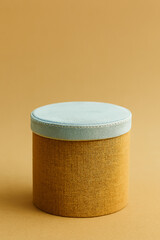 Round textured display podium with a soft blue top on a warm brown background
