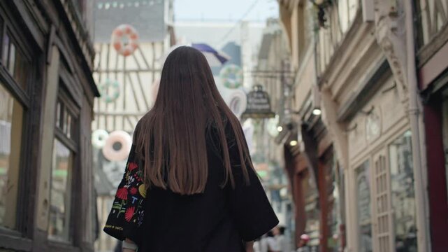 Woman walking through a French city. Travel and tourism historical architecture impressions Europe.