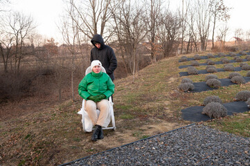 Winter afternoon relaxation at a serene garden, with a woman enjoying the fresh air while a friend...