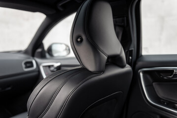 Front seat with headrest in modern car - rear three quarter view. Car interior leather seat -...