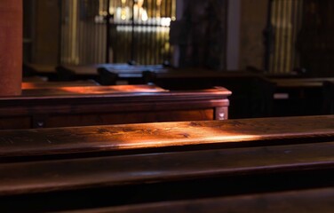 Sunlight streaming through church windows illuminating wooden pews