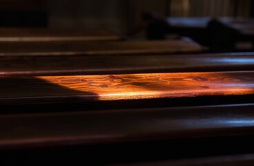 Sunlight illuminating wooden bench in dimly lit room