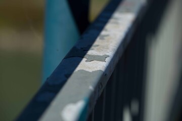 Weathered metal railing with peeling paint in natural light