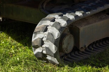 Close-up of weathered tank track on grass surface