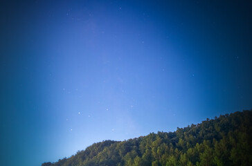 The Milky Way is faintly visible due to the moonlight of the full moon