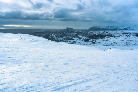 White glacier mountain with snowmobile track on summit in winter