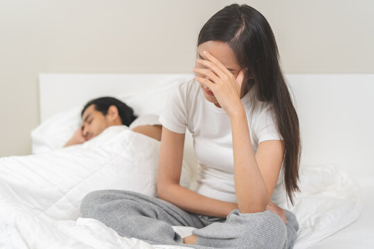 Angry, depressed, frustrated asian couple quarrel, fighting on bed in conflict, divorce or relationship problem, stress from marriage, fight and argument, unhappy married couple and sexual impotent.