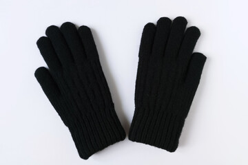 Black wool winter gloves. White background, top view.
