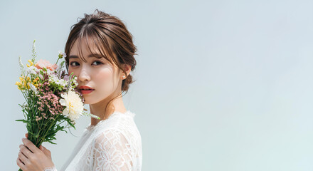 白いレースのドレスを着た若い女性がカラフルな花束を持つポートレート