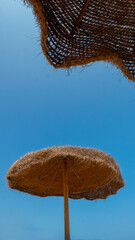 Stuffed fiber umbrellas on the Mediterranean beach