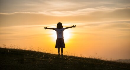 Fototapeta premium Child standing on a grassy hill reaching toward the rising sun, symbolizing healthy future