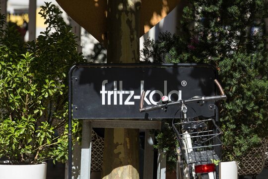 Villach, Austria - September 04, 2025: Fritz-Kola sign displayed prominently in a vibrant outdoor setting, surrounded by lush greenery and a bicycle, showcasing urban lifestyle and branding