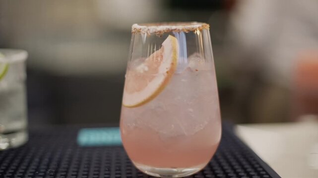 una bebida refrescante con toronja servida por un bartender