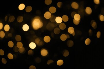 Obraz premium Golden winter lights abstract texture with festive bokeh on dark background