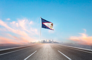 American Samoa national flag with mast waving with beautiful skyline. A view from highway. American...