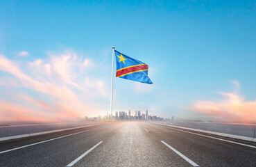 DR Congo national flag with mast waving with beautiful skyline. A view from highway. DR Congo...
