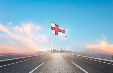 Faroe Islands national flag with mast waving with beautiful skyline. A view from highway. Faroe...