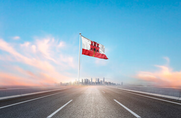 Gibraltar national flag with mast waving with beautiful skyline. A view from highway. Gibraltar...