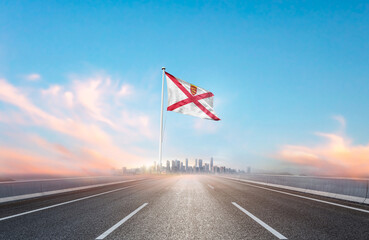 Jersey national flag with mast waving with beautiful skyline. A view from highway. Jersey national...