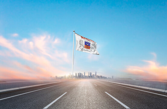 Mayotte national flag with mast waving with beautiful skyline. A view from highway. Mayotte national flag for independence day. - Powered by Adobe