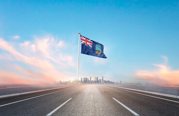 Montserrat national flag with mast waving with beautiful skyline. A view from highway. Montserrat...