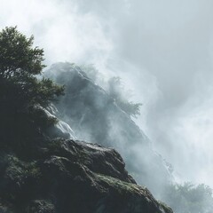 Obraz premium Dramatic misty mountain vista featuring rocky peaks and atmospheric cloud cover creating an