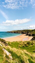 A beautiful beach scene with a vast expanse of sand, surrounded by lush green hills, under a vibrant blue sky dotted with fluffy white clouds.